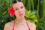 Millie Bobby Brown con bikini rojo; vegetación atrás