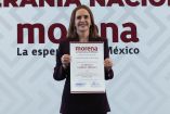Clara Luz Flores posa en solitario sosteniendo su nombramiento de la Comisión Nacional de Elecciones de Morena para el estado de Nuevo León.