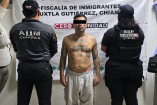 Fotografía de la detención de José Edwin Wilberto Ventura Cerón, alias 'El Muerto', presunto líder de la Pandilla 18. Aparece con el torso desnudo mostrando tatuajes, custodiado por policías frente a una lona de la Fiscalía de Inmigrantes en Chiapas.
