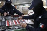 Agentes de la SSPC manipulan y revisan maquinaria industrial utilizada para el empaquetado automático de cajetillas de cigarros.