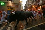 La lluvia hizo que tanto toros como corredores resbalaran en distintos puntos del recorrido que cruza la ciudad de Pamplona, en el norte de España / Foto: AP