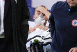 Christian Eriksen salió de la cancha en camilla y en una de las imágenes se llevó su mano izquierda a la frente (Reuters)
