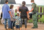 Un grupo de niños y adultos se encuentra con la Patrulla Fronteriza en Texas. Foto: AFP