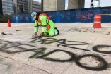 Román un colaborador del área de Servicio Urbanos trabaja de rodillas tallando con un cepillo de alambre cada uno de los grafitis. Foto: Efrén Argüelles 