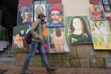 Un hombre camina junto a réplicas de dibujos del artista colombiano Fernando Botero en su 90 cumpleaños en Bogotá. Foto: AFP