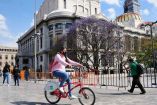 Mujer pedaleando una bicicleta de Ecobici