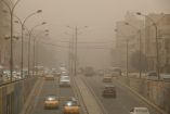Autos transitan en Bagdad en medio de una tormenta de arena.