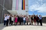 Funcionarios frente a las banderas de la comunidad LGBT+