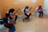 Niños aprendiendo a tocar la guitarra.