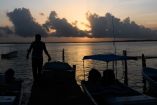 Lanchas y un lanchero durante el amanecer en Yucatán