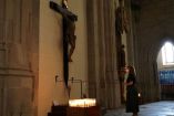 Una mujer reza ante una imagen de Cristo en España.