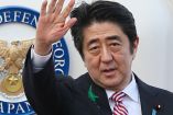Shinzo Abe, exprimer ministro de Japón, con traje y corbata saludando