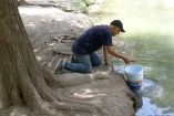 Hombre recolectando agua de área natural protegida