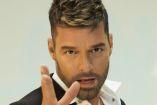 Ricky Martin viendo a la cámara y con la mano derecha abierta