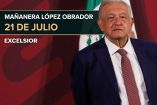 AMLO sonriendo y en traje en una de sus conferencias