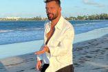 Ricky Martin caminando con camisa blanca y mar de fondo