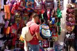 Un hombre compra una mochila en un comercio en el marco del regreso a clases.