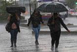 Personas caminan bajo la lluvia