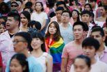 Una mujer con una bandera del movimiento LGBT+ participa en una marcha en Singapur.