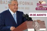 AMLO sonriendo, vestido de traje azul marino y corbata azul claro