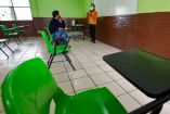 Un salón de clases vacío, solamente están el maestro y una persona