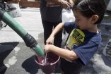 Niño recolecta agua de una pipa en su cubetita