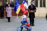 Momento en que el niño disfrazado de Superman da vueltas con su bicicleta alrededor de Boric.
