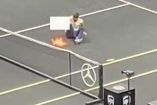 Hombre sentado en medio de cancha de tenis y fuego al lado 