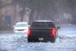 Autos circulan por una calle inundada en Charleston, Carolina del Sur.