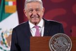 AMLO de traje oscuro y sonriendo