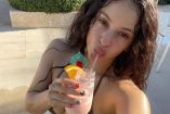 Rosalía con traje de baño café y piña colada en la mano