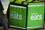 Mochila verde de Uber Eats en el piso, junto a llanta de bicicleta