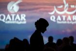 Una mujer y al fondo el logo de Qatar