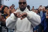 Kanye West con lentes y sudadera blanca manos al frente, fanáticos de fond