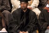 Kanye West serio con birrete y sotana negra sentado 
