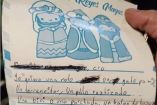 Carta con Reyes Magos impresos y lista de peticiones; mano sujetando