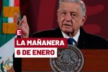 AMLO de traje oscuro y alzando la mano derecha