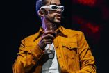 Bad Bunny con lentes blancos atuendo amarillo en concierto