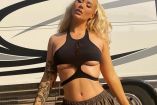 Iggy Azalea con top negro y pants gris; tráiler atrás
