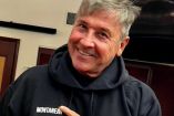 Ricardo Montaner con sudadera negra sonriendo: puertas de fondo
