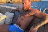 Conor McGregor sin playera en ropa interior azul, arriba de yate