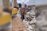 Un hombre carga a una bebé entre ruinas tras terremoto en Siria