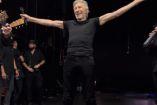 Roger Waters con pantalón y playera negra, alzando brazos
