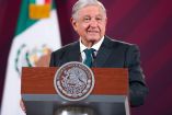 AMLO de traje gris y corbata verde en una mañanera