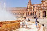 Personas padecen el calor cerca de una fuente en una plaza en Europa.