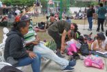 Migrantes que salieron en caravana descansan en un parque