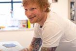 Ed Sheeran con playera blanca recargado en barra