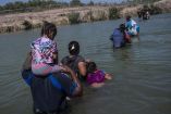 Migrantes cruzando el río Bravo