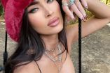 Megan Fox con sombrero rojo y mano en mejilla, pecho descubierto