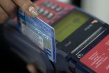 Tarjeta bancaria pasa por terminal para realizar compra